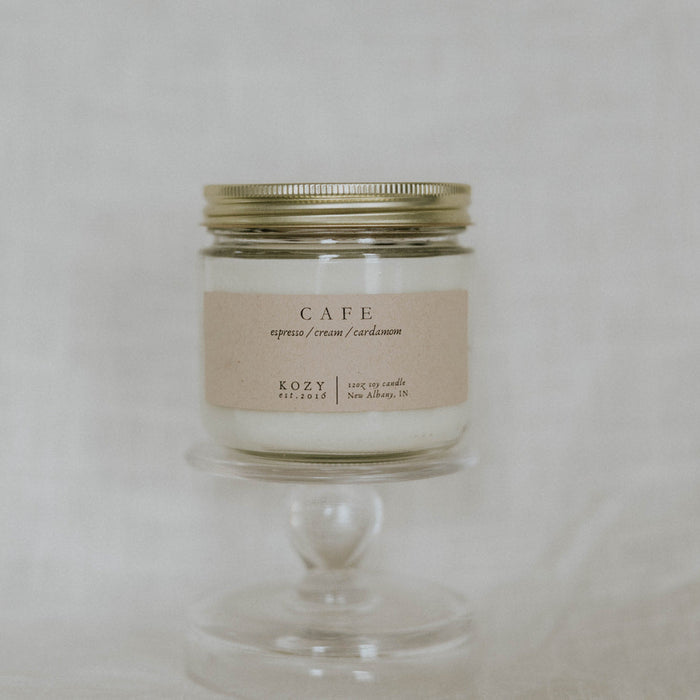 Candle in a glass jar with a metal lid on a neutral background