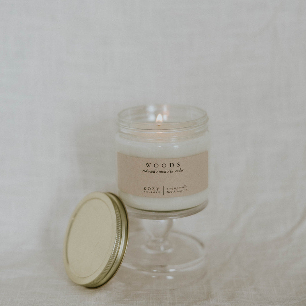 Glass candle with a label on a plain background