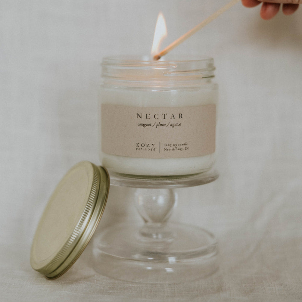 Candle being lit with a match, labeled 'Nectar' on a neutral background
