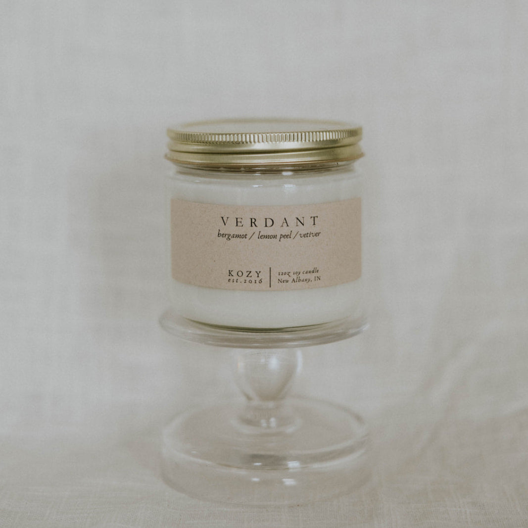 Candle in a glass jar with a metal lid on a light background