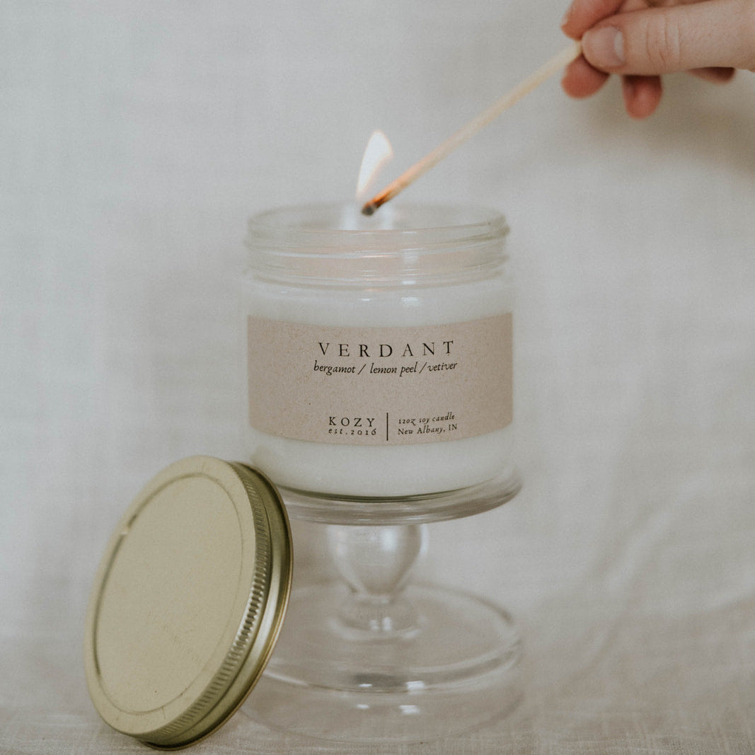 Candle being lit with a match, labeled 'Verdant' on a neutral background