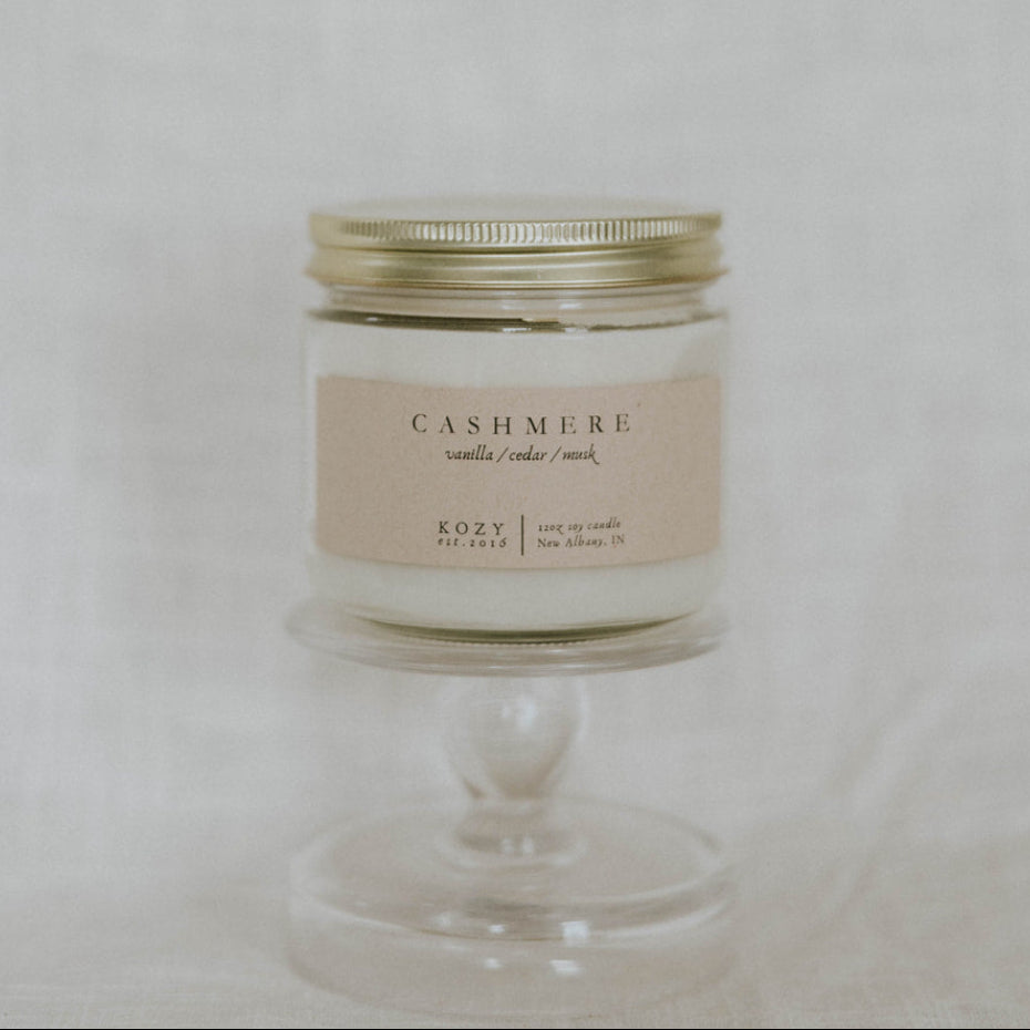 Candle in a glass jar with a metal lid on a light background