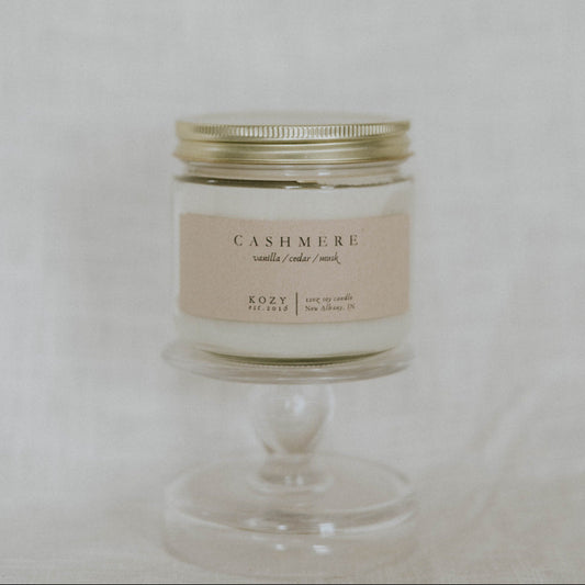 Candle in a glass jar with a metal lid on a light background