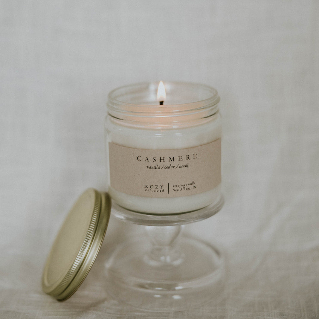 Glass candle with a label on a neutral background