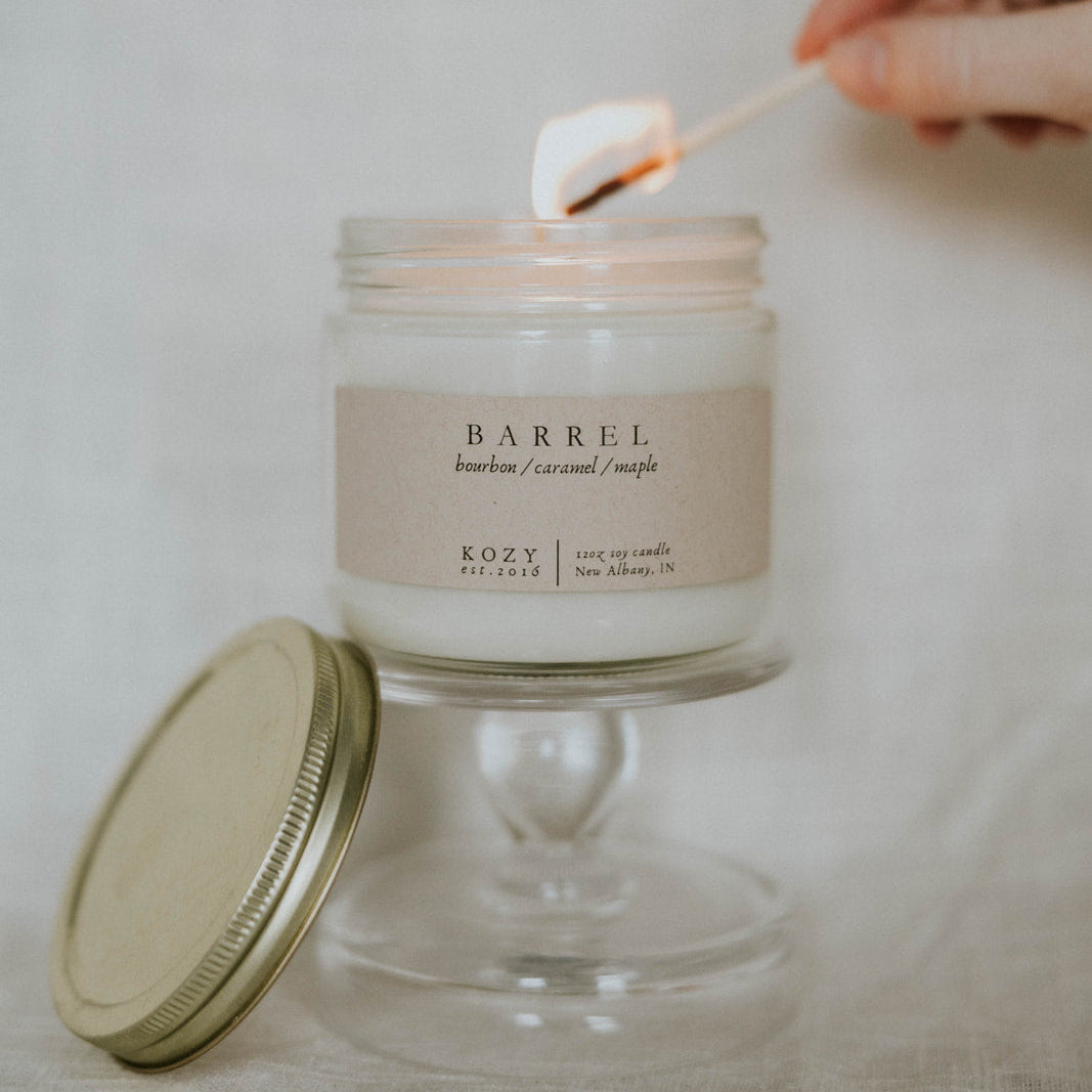 Person lighting a candle labeled 'Barrel' with a match.