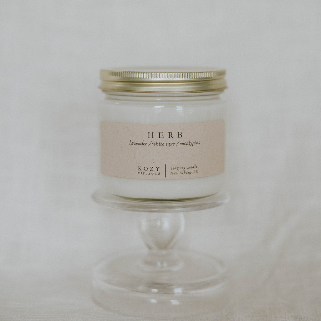 Candle in a glass jar with a metal lid on a white background