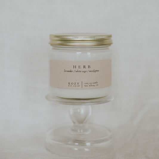 Candle in a glass jar with a metal lid on a white background