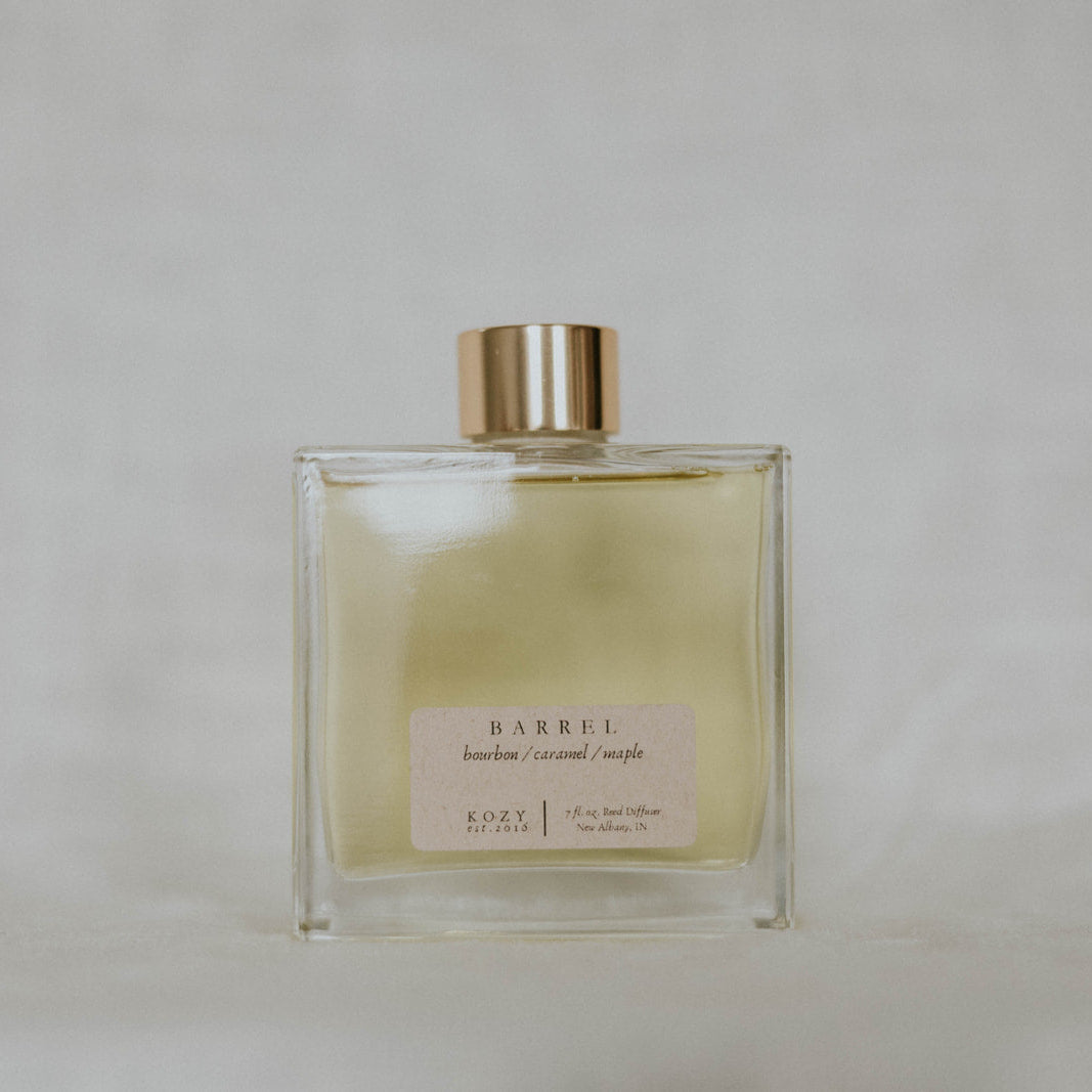 Clear glass bottle with gold cap on a light gray background