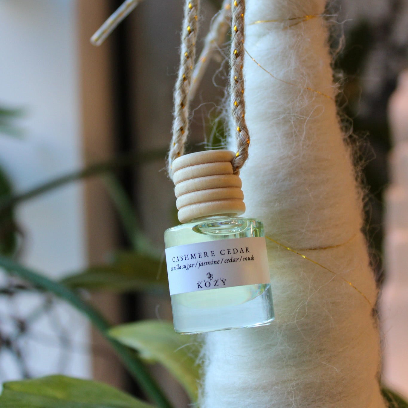 Car Diffuser in the scent 'Cashmere Cedar' hanging from a decoration.