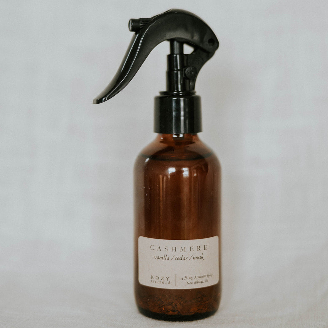 Brown spray bottle with black nozzle on a light gray background