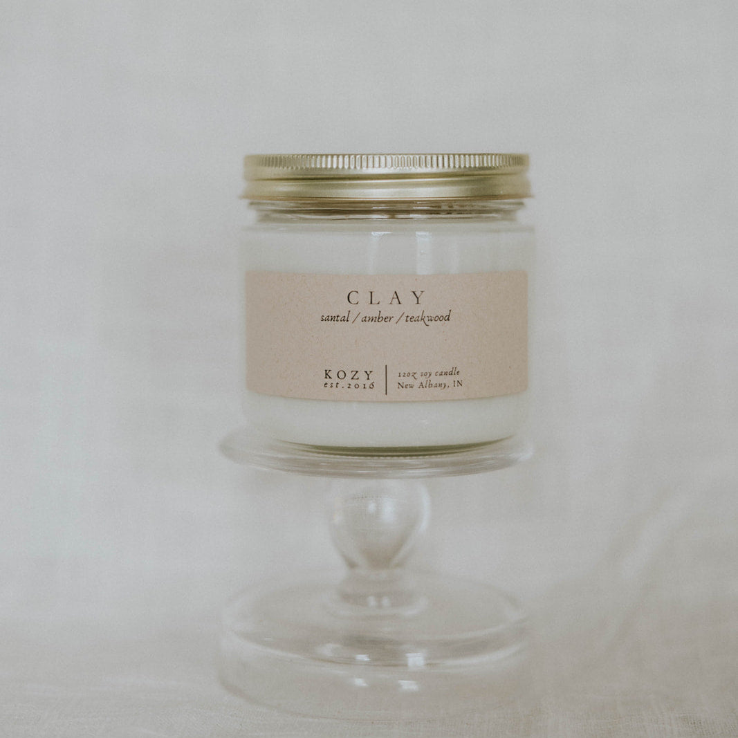 Candle in a glass jar with a metal lid on a white background
