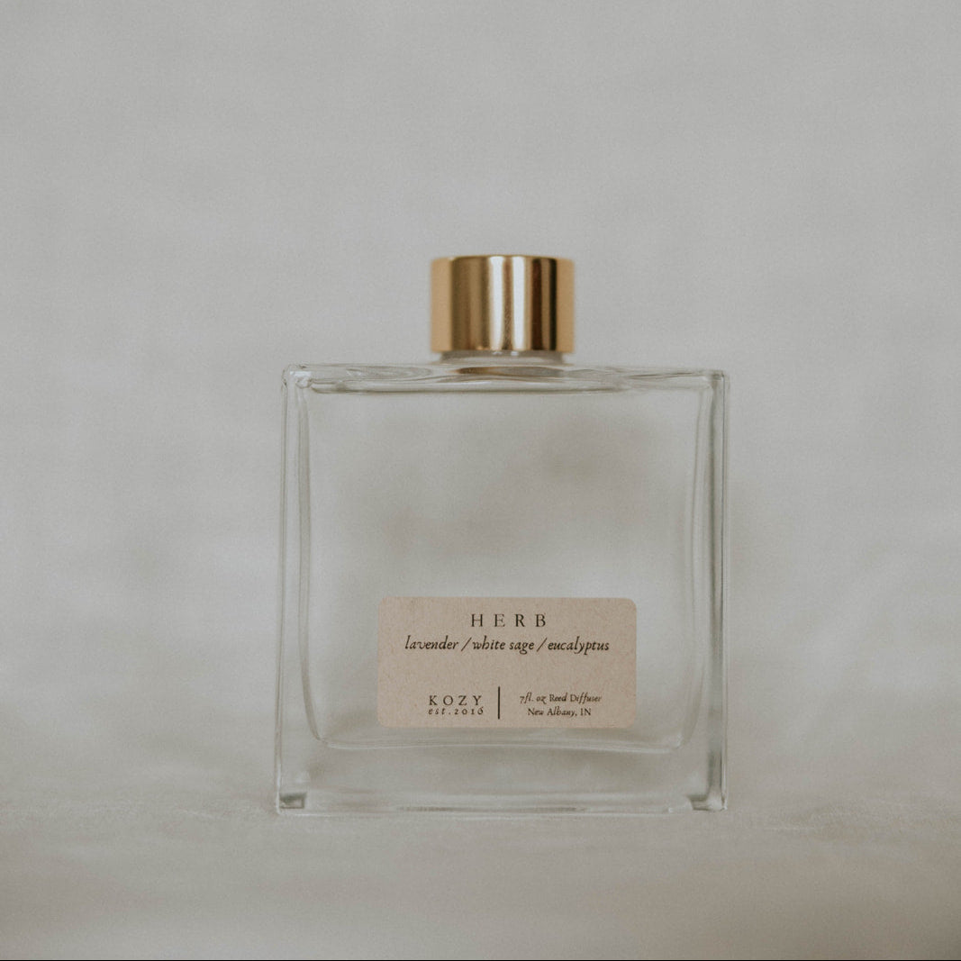 Clear glass bottle with gold cap on a light gray background