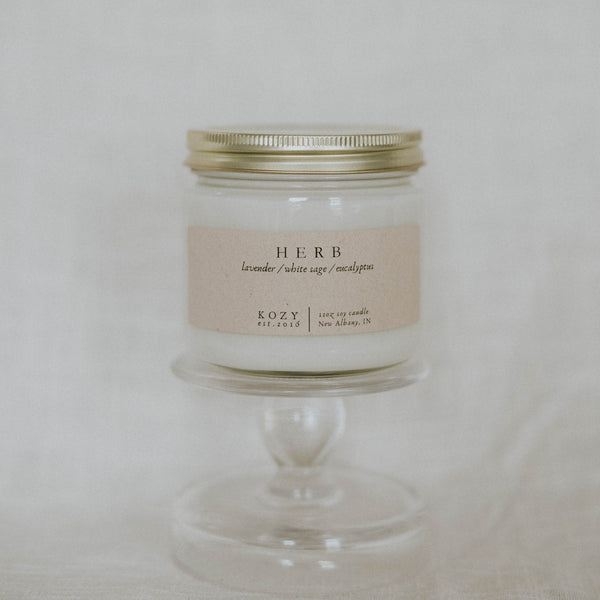 Candle in a glass jar with a metal lid on a white background