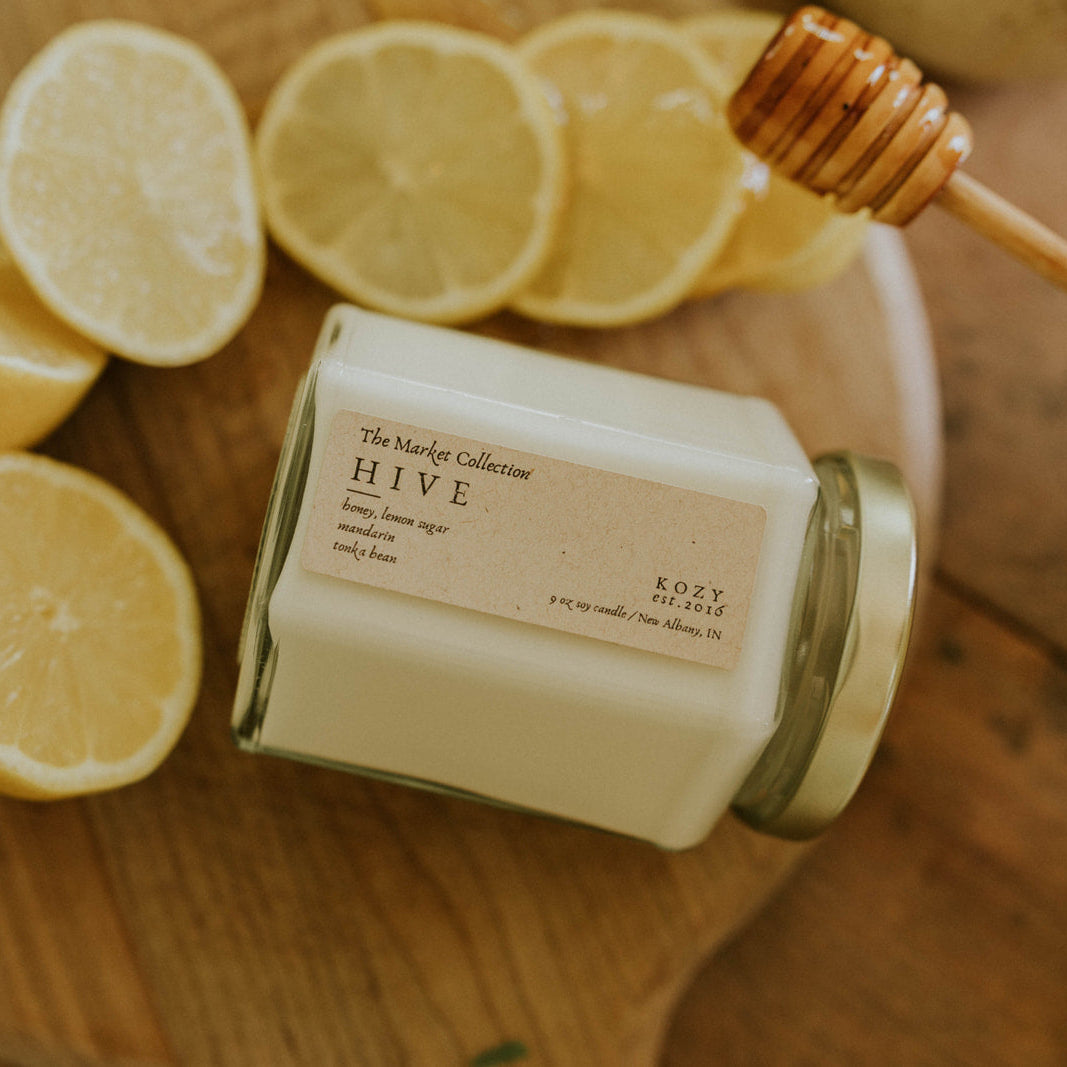 Candle 'Hive Scented' on wooden tray with lemons and honey