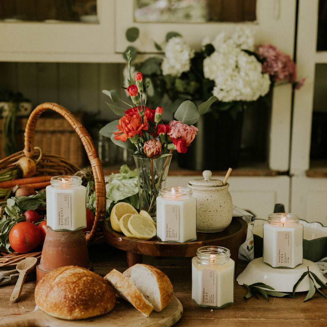 Table with bread, candles, lemons, and flowers in a home setting