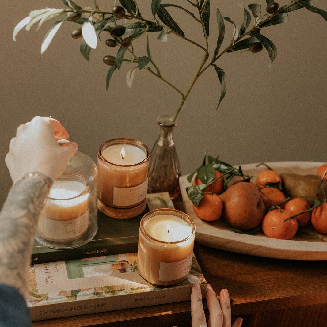 Candles and a fruit platter on a table with a neutral background