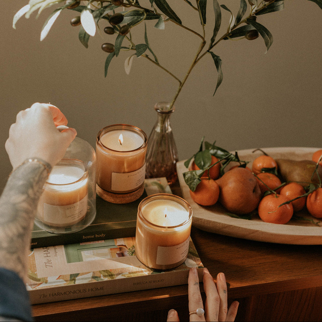 Candles and a fruit platter on a table with a neutral background