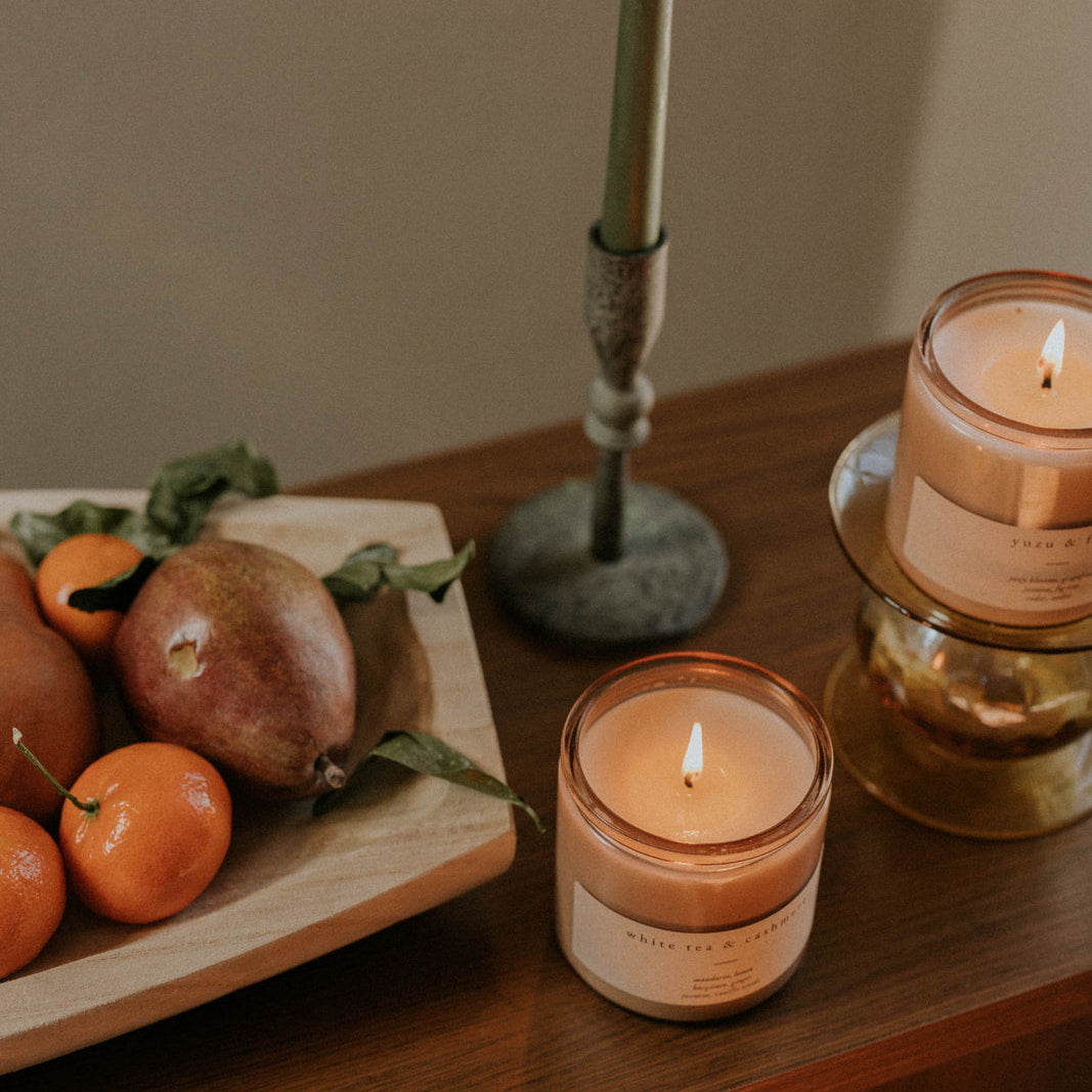 Candlelit scene with candles and fruits on a wooden surface