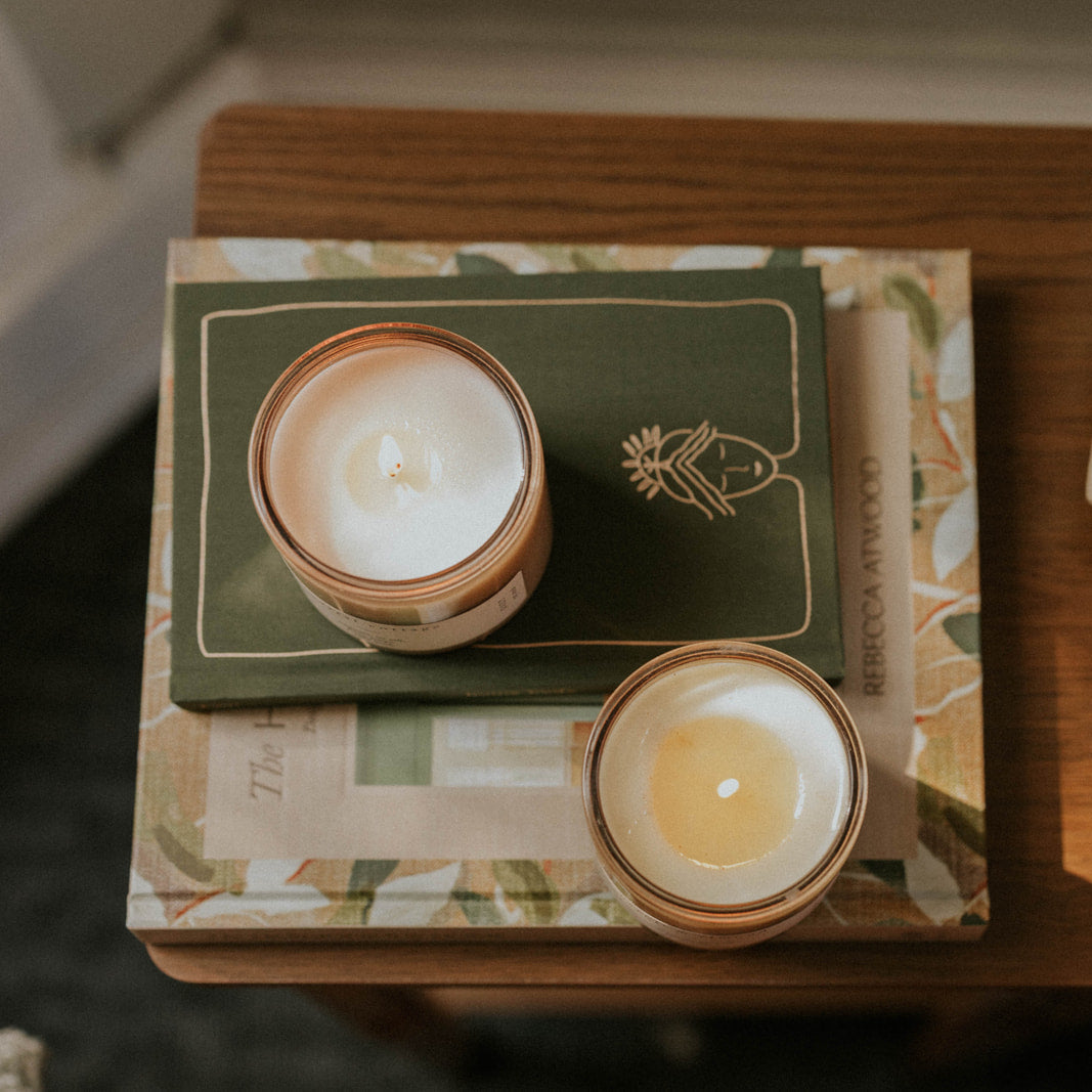 Candlelit scene with books and oranges on a wooden surface