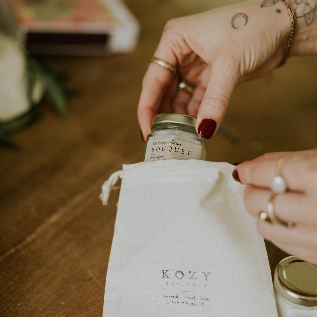 Person placing candle in Kozy Kandles bag