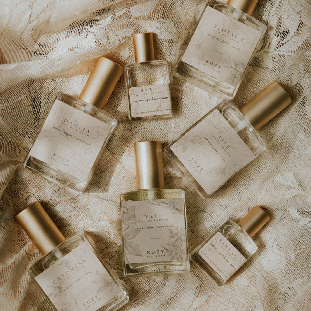 Set of perfume bottles on a textured beige fabric background
