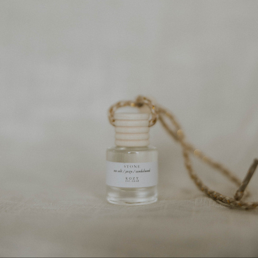 Small car diffuser, scent 'Stone', with a rope on a neutral background