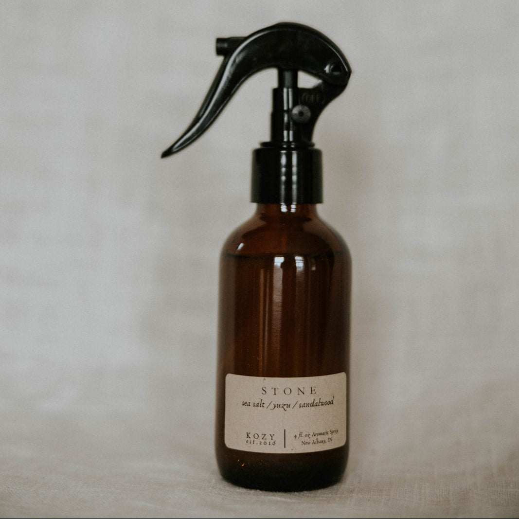 Brown spray bottle with black nozzle on a light gray background