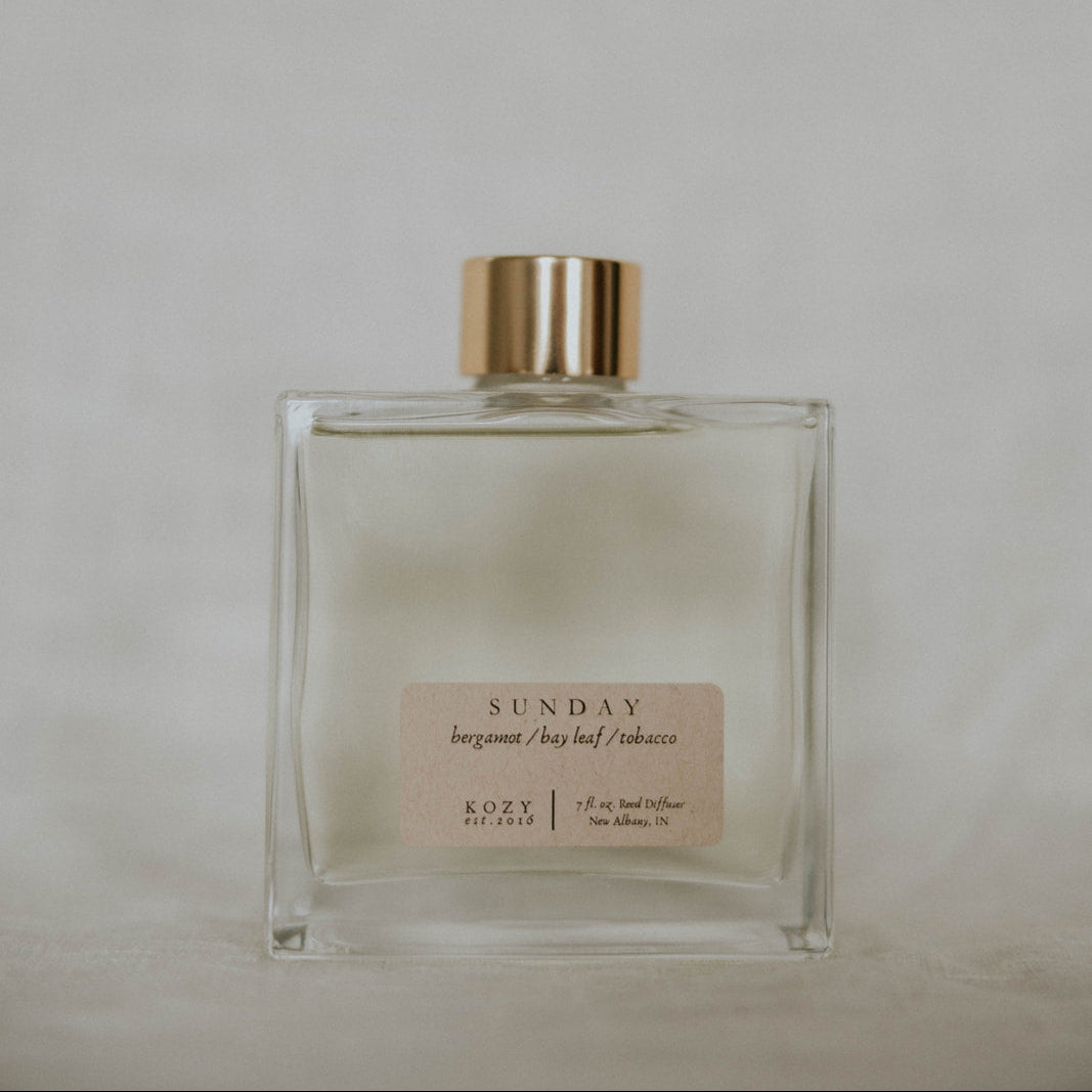 Clear glass bottle with gold cap on a light gray background