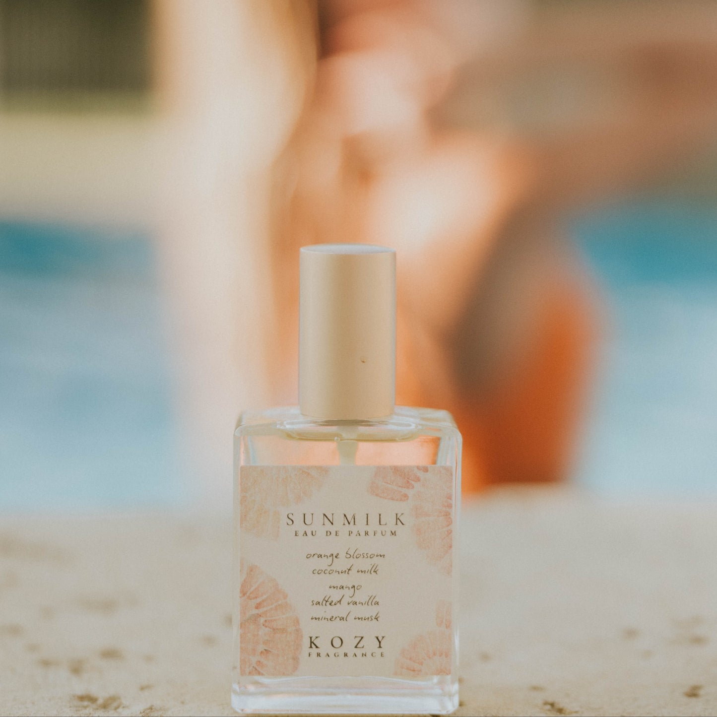 Kozy Fragrance bottle with blurred person in the background