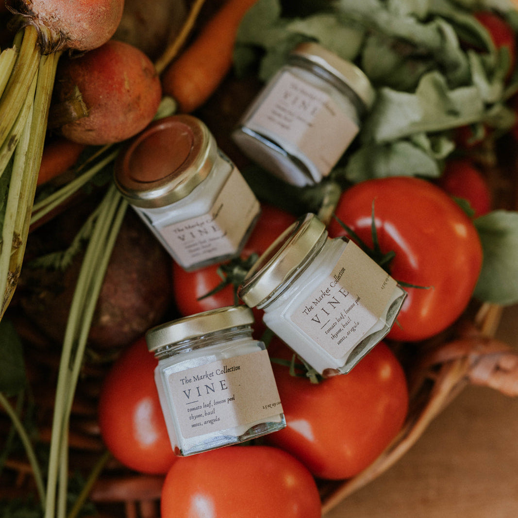 Vine Candles in a basket with tomatoes and other produce