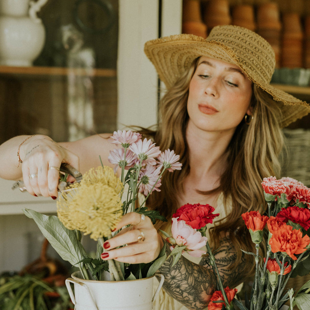Woman arranging flowers in a kitchen setting