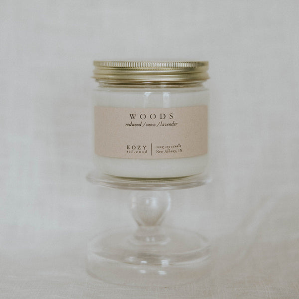 Candle in a glass jar with a gold lid on a white background