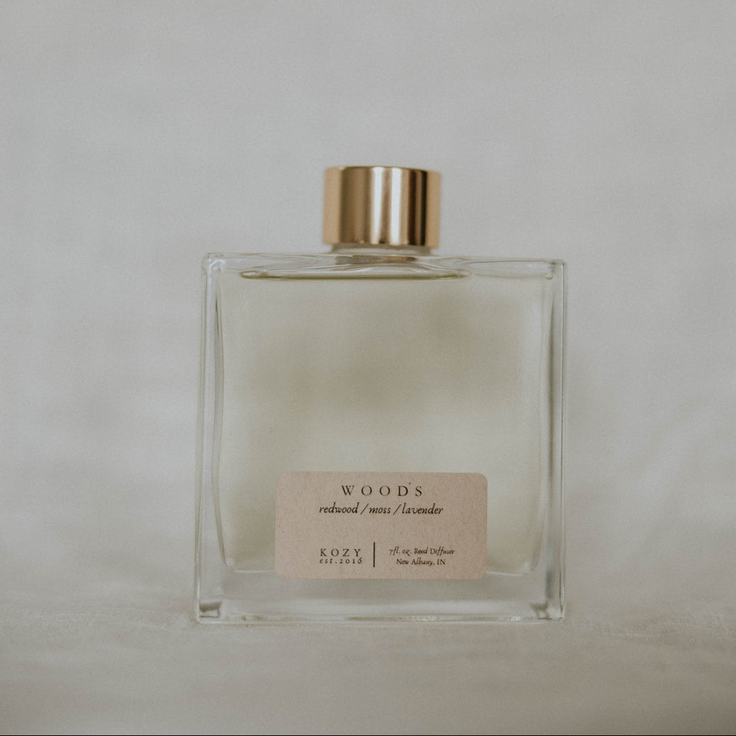 Clear diffuser bottle bottle with gold cap on a light gray background